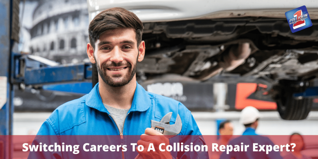 Man smiling wearing body shop workwear holding a wrench standing in front of a vehicle he is working on.